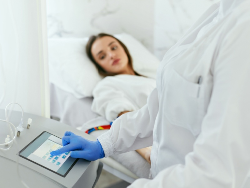 Eine Patientin unterzieht sich einer Ozontherapie, beaufsichtigt von einem medizinischen Fachpersonal. Die Therapie wird zur Behandlung von chronischen Schmerzen und zur Verbesserung der Sauerstoffversorgung des Gewebes eingesetzt.