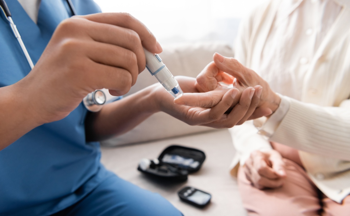 Ein Gesundheitsdienstleister überprüft den Blutzuckerspiegel eines Patienten mit einem Blutzuckermessgerät. Dieser Prozess ist entscheidend für die effektive Kontrolle und Behandlung von Diabetes mellitus Typ 2, insbesondere im Kontext von komplementärmedizinischen Ansätzen.