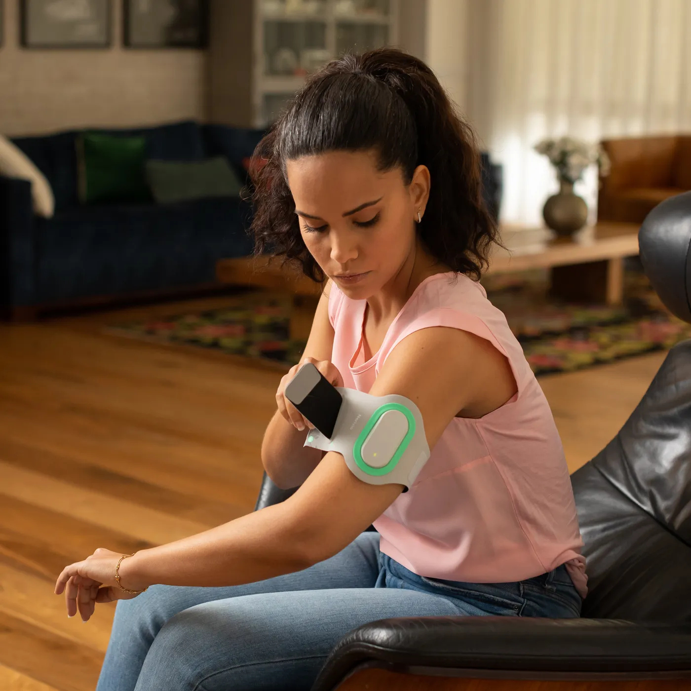 Frau nutzt das Nerivio-Armband zur Migränebehandlung durch Neuromodulation am Oberarm – app-gesteuerte, nicht-medikamentöse Therapie gegen Migräne.